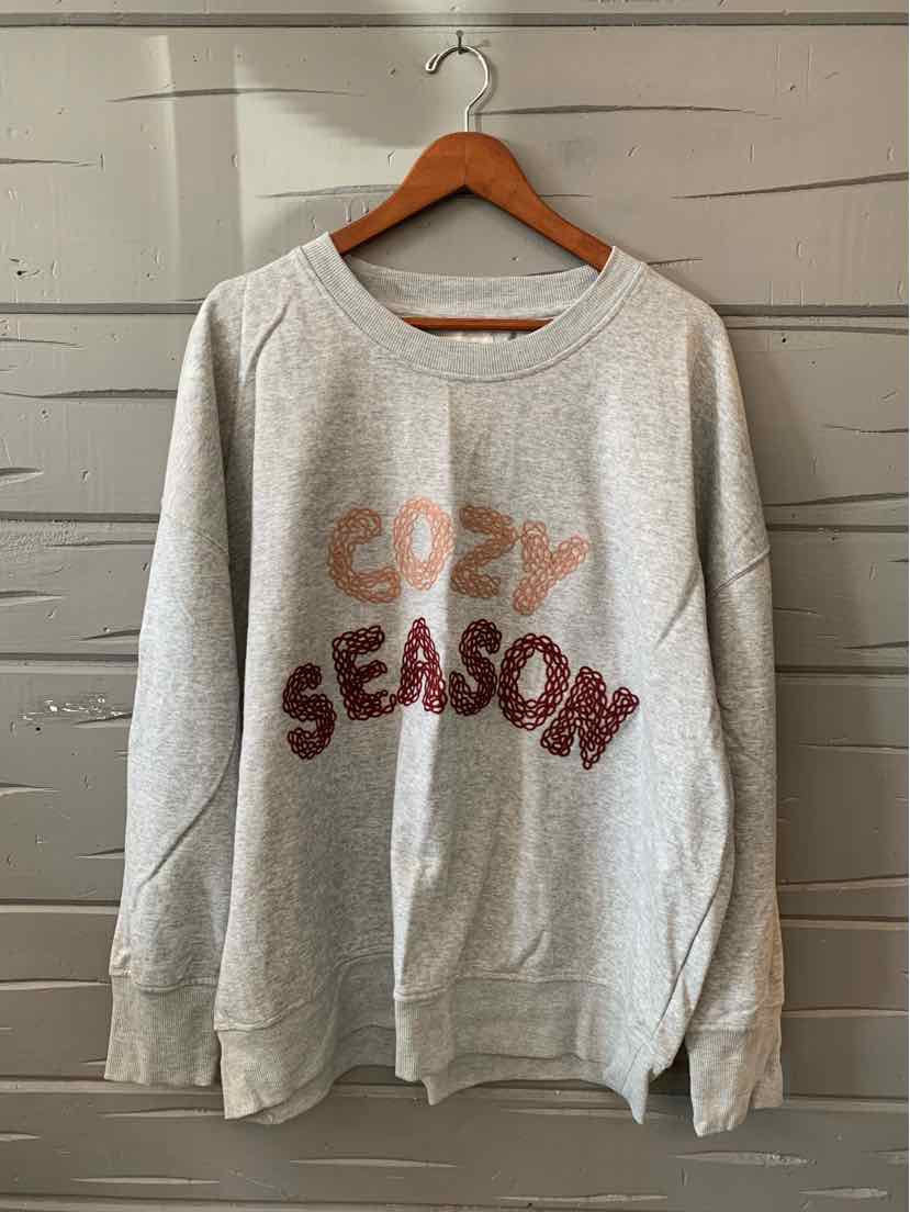Gray women's sweater with a relaxed fit, crew neckline, and pink “Cozy Season” lettering.