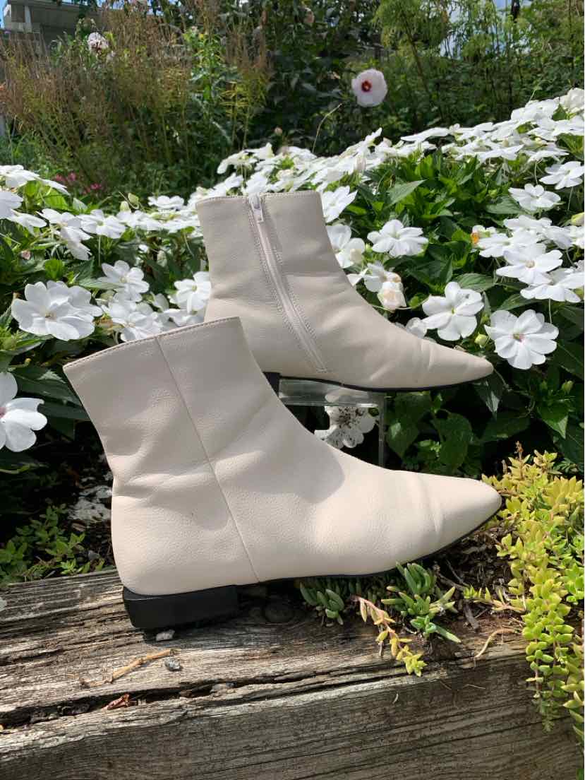 Cream-colored leather ankle boots with pointed toes and low black heels, size 6.5.