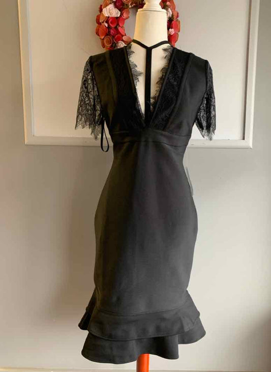 Black short-sleeve dress with lace sleeves and V-neckline, fitted waist, and ruffled hem.