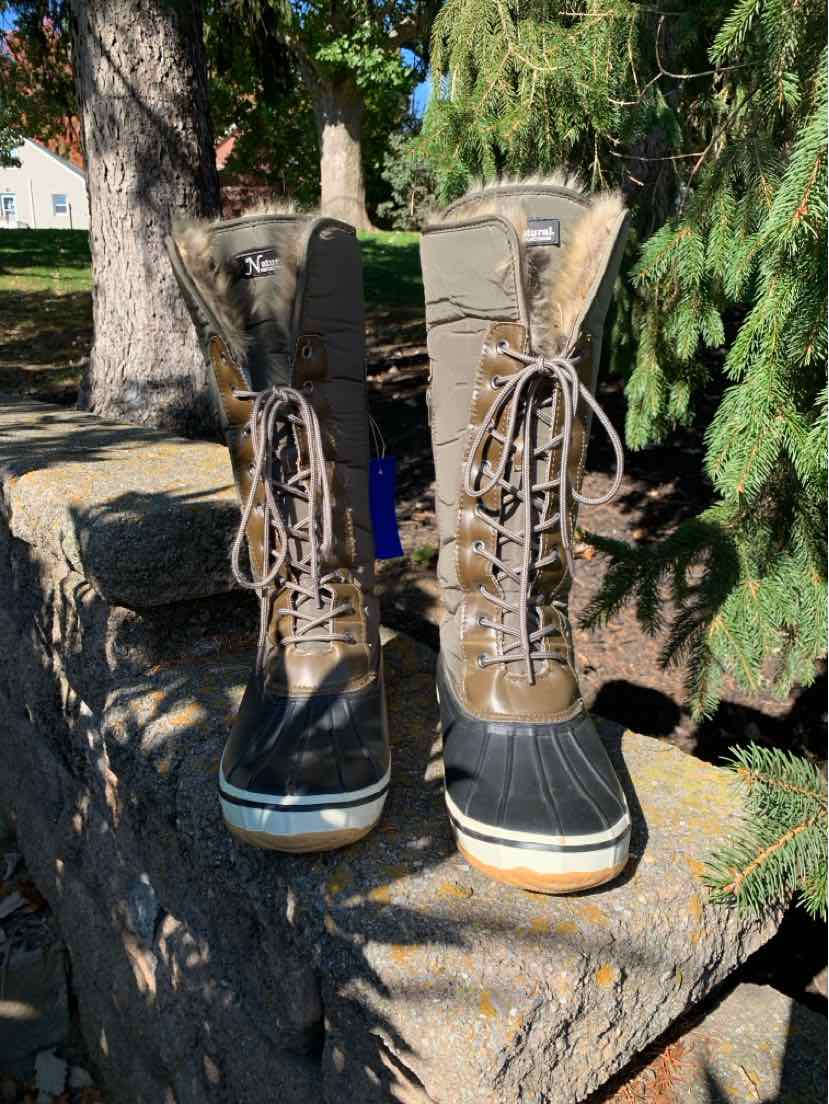 Pair of tan and brown lace-up women’s boots with black padded collars, eyelets, and thick dark soles.