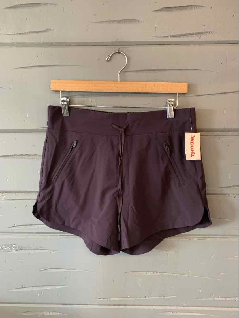 Black athletic shorts with side pockets and an elastic waistband, hanging on wooden hanger.