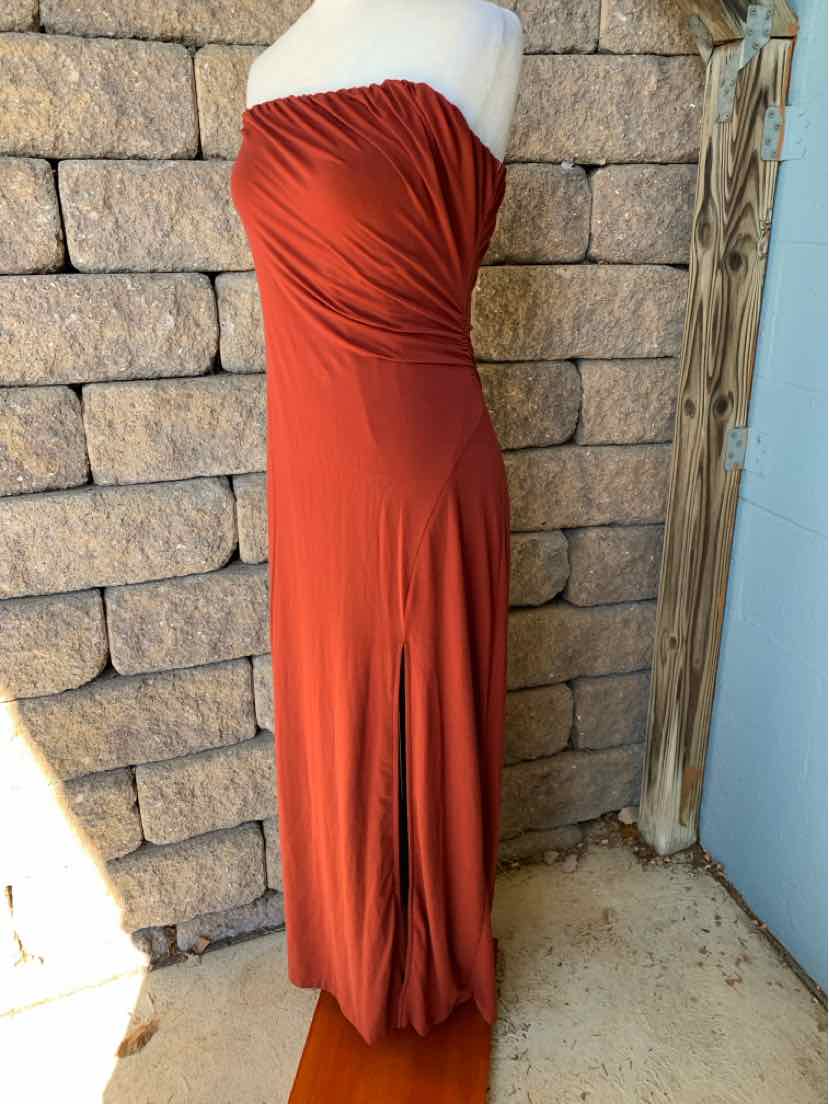 Burgundy-red strapless maxi dress with a ruched, draped bodice and long flowing skirt.