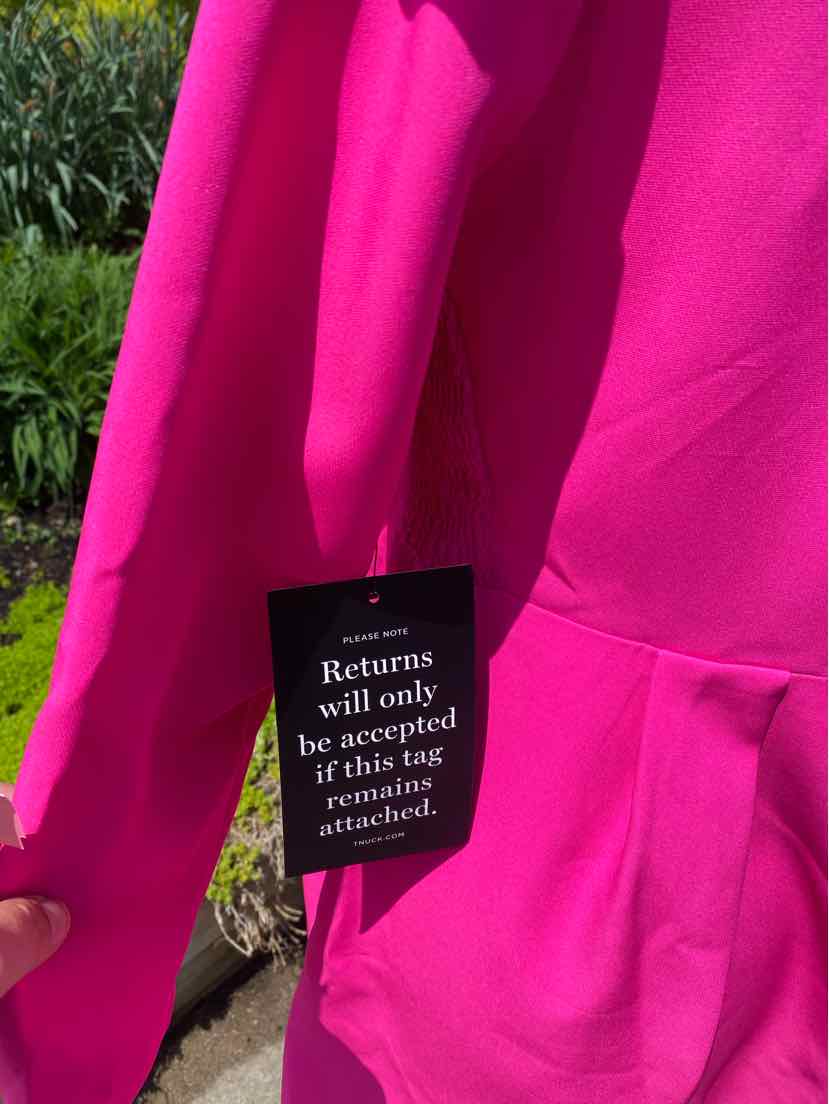 Bright pink hoodie with kangaroo pocket and black care tag attached.