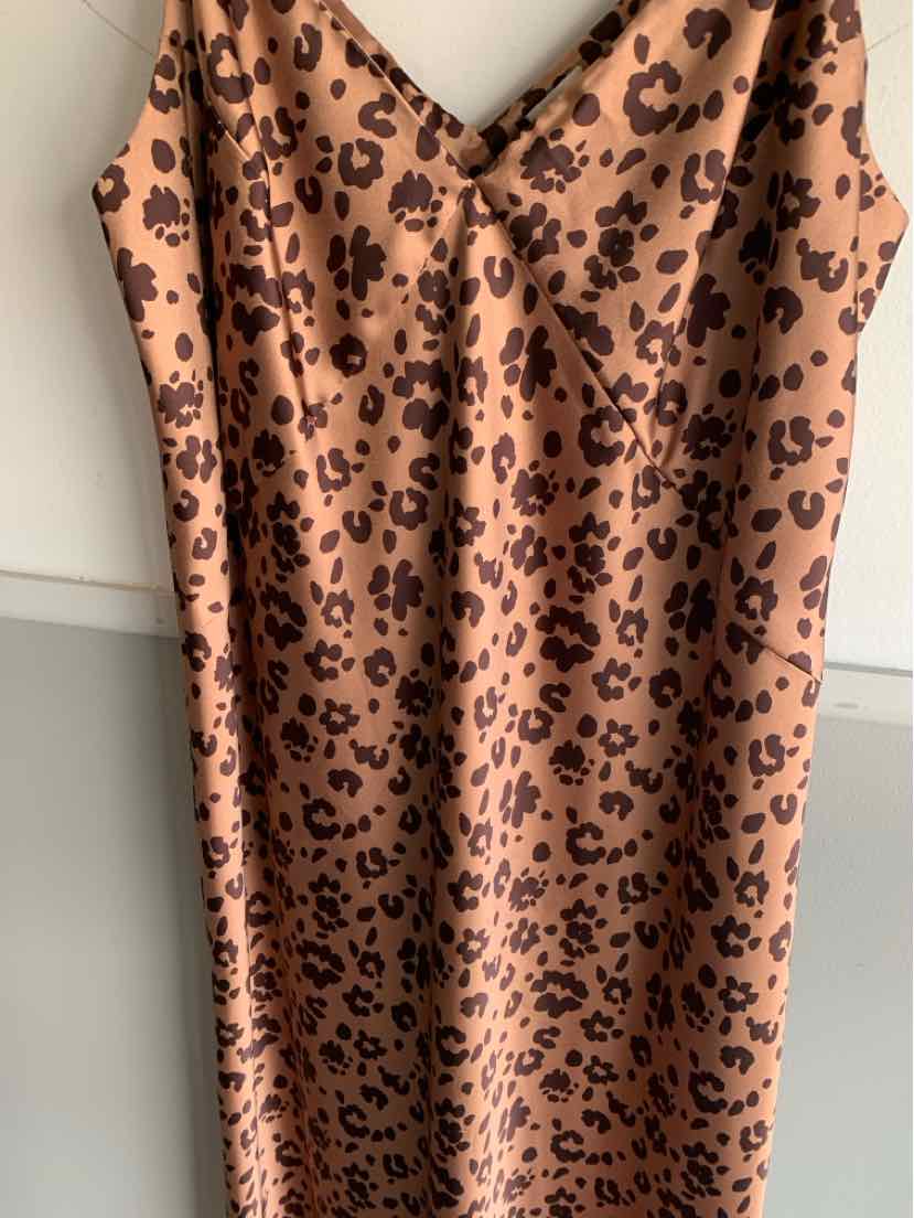 Beige satin slip dress with black cheetah print, V-neckline, and thin spaghetti straps.