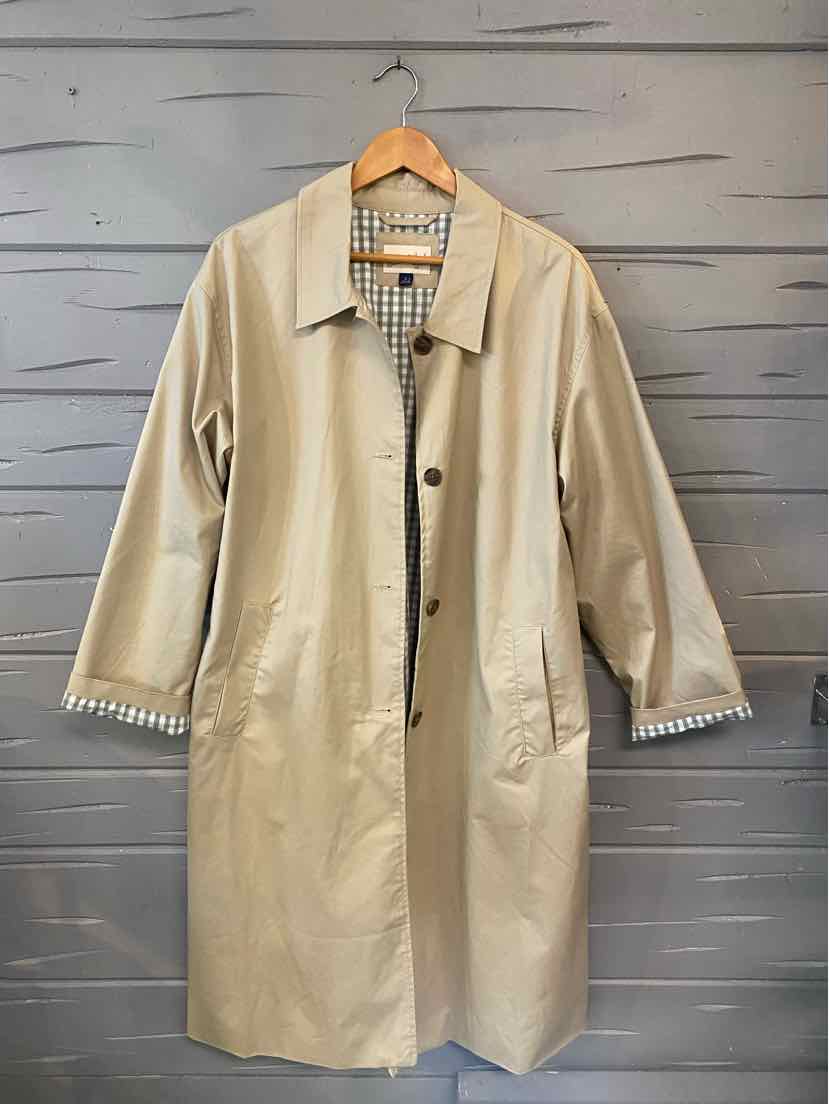 Tan knee-length coat with button closure, classic collar, and gingham lining visible at cuffs.
