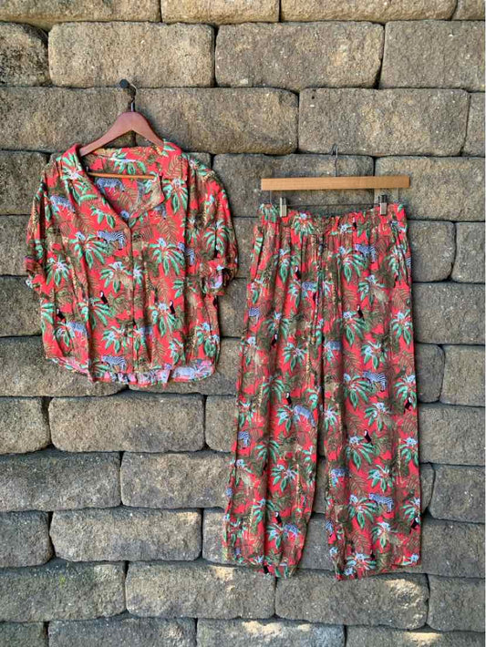 Red tropical print two-piece set with short-sleeve button-up shirt and elastic waist pants.