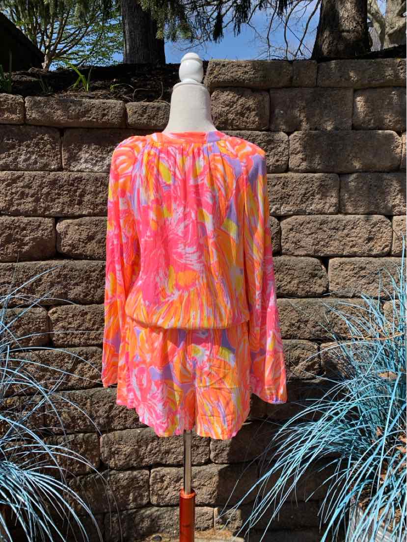 Pink and orange floral long-sleeve blouse with gathered waist and round neckline.