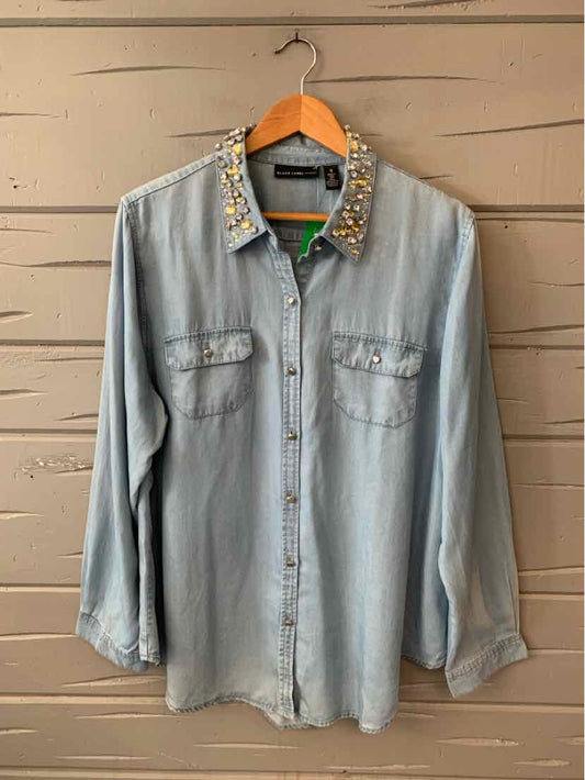 Light blue chambray long-sleeve shirt with button front, chest pockets, and floral embroidery on collar.