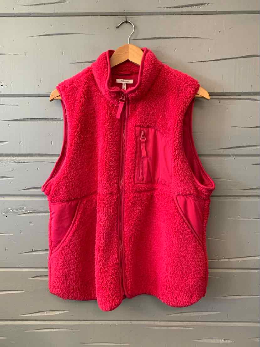 Bright pink sleeveless fleece vest with a zip front, stand collar, and two lower pockets.