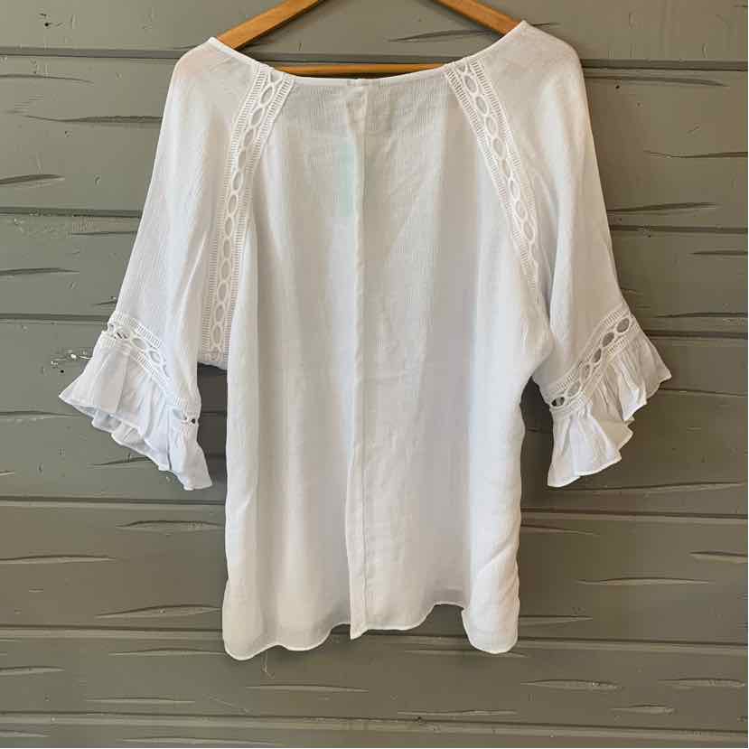 White blouse with 3/4 ruffled sleeves and lace inset details on front and sleeves.