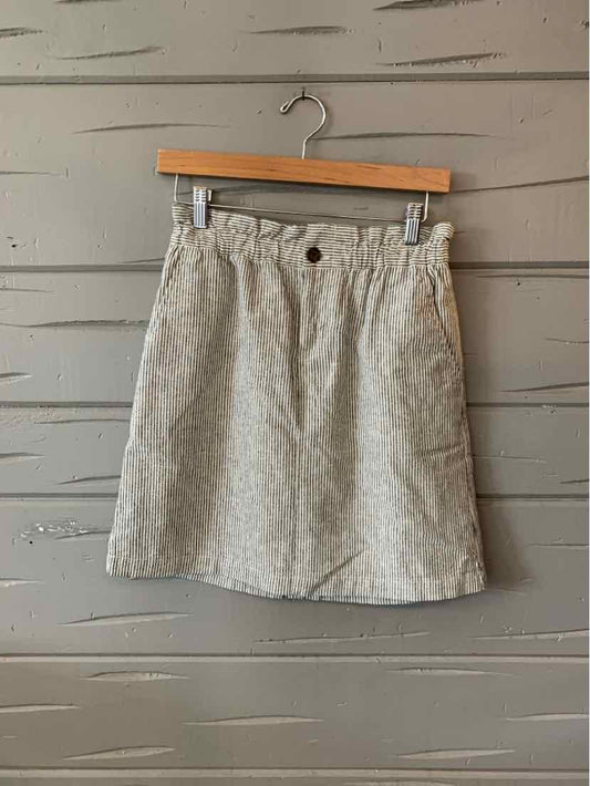Light beige linen blend mini skirt with front button and elastic waistband.