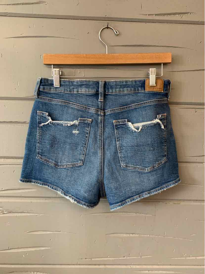 Blue denim shorts with frayed edges and distressed back pockets, size 6.