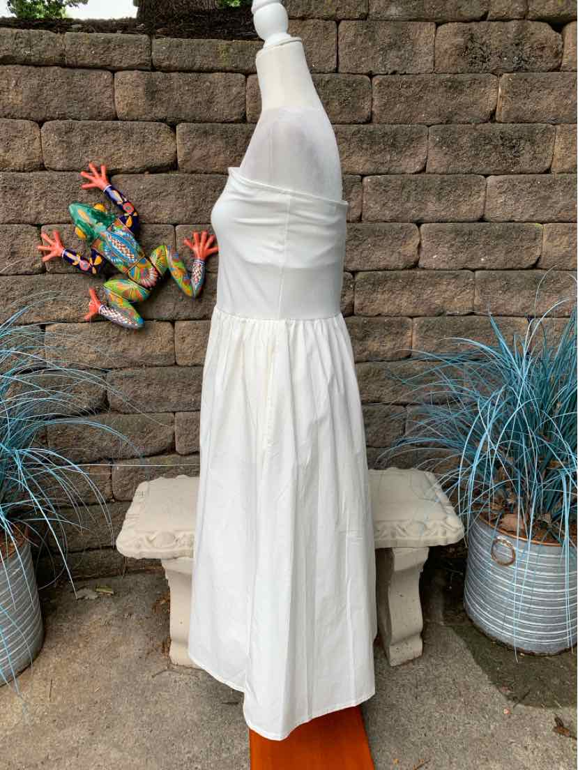 White sleeveless midi dress with fitted bodice and gathered skirt on mannequin outdoors.