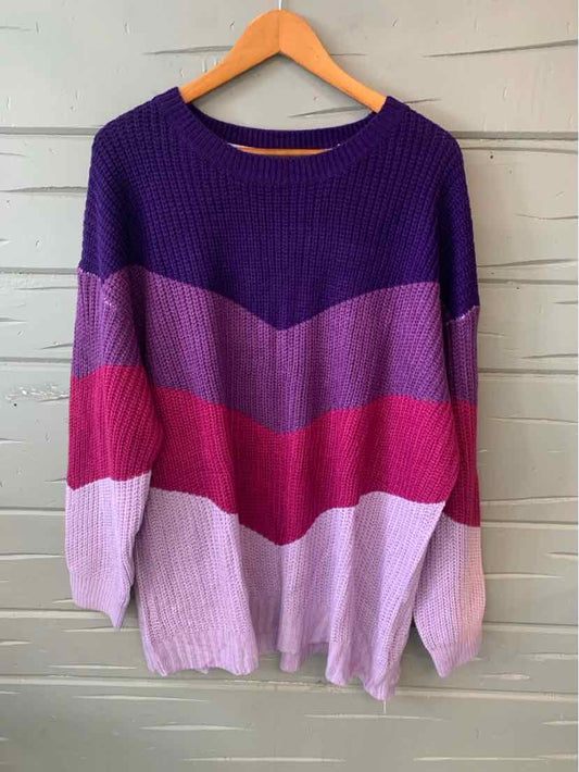 Plus size color block sweater with purple, lavender, pink, and light pink chevron stripes on wood hanger.