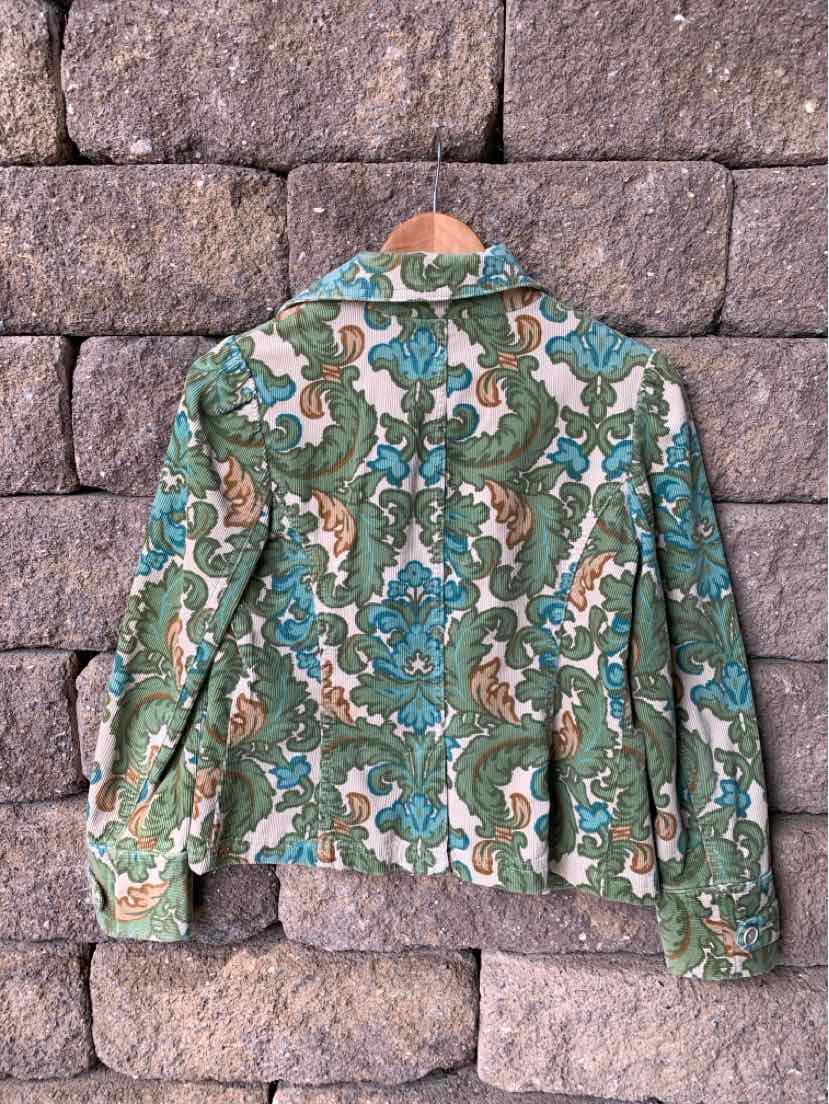 Green and cream corduroy jacket with blue and brown paisley print, long sleeves, and collar.