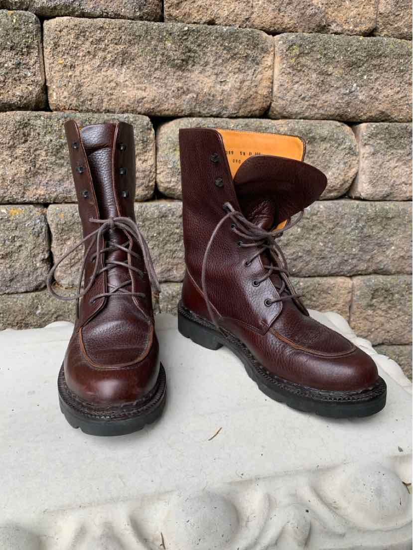 Dark brown leather lace-up boots with rugged black rubber soles and padded collars.