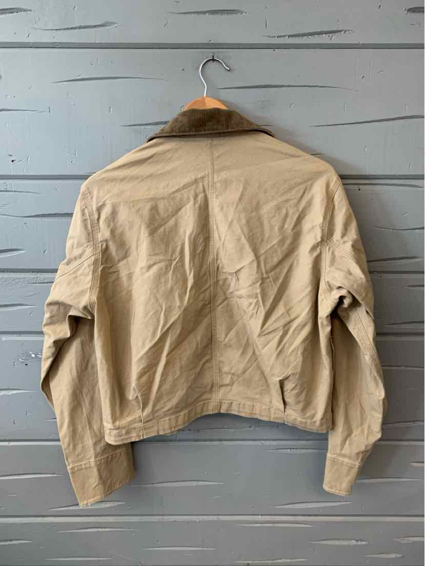 Tan cotton jacket with long sleeves and a straight hem hanging on a wooden hanger.