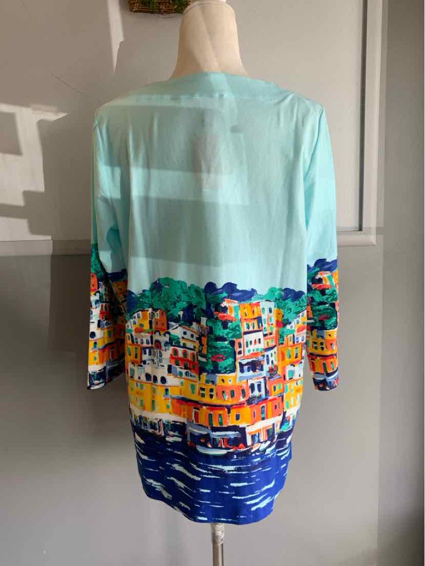 Light blue long-sleeve blouse with vibrant cityscape print and water reflections on lower half.