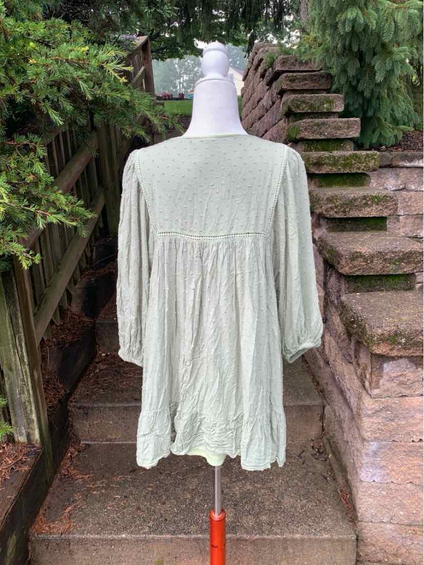 Light green loose-fit blouse with three-quarter sleeves and gathered back detail.