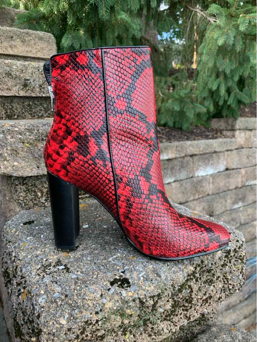 Red ankle boot with black snake print pattern, pointed toe, and chunky high heel.