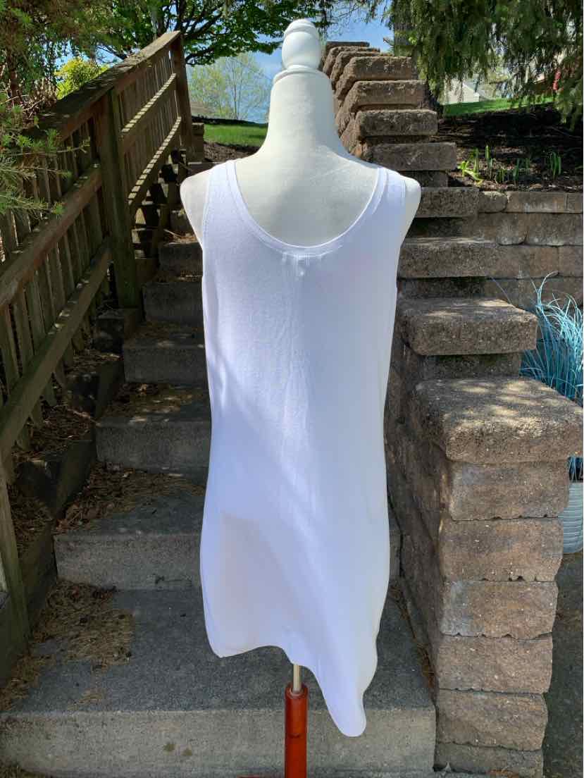 White sleeveless knit dress with scoop neckline, displayed on dress form outdoors.