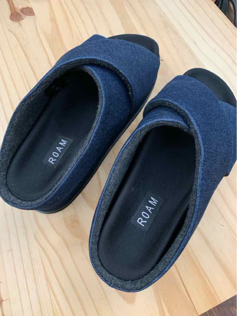 Navy blue slip-on shoes with rounded toes, soft fabric upper, and cushioned black insoles labeled ROAM.
