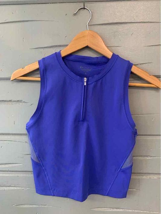 Sleeveless royal blue athletic crop top with front zipper in size XS on wooden hanger.
