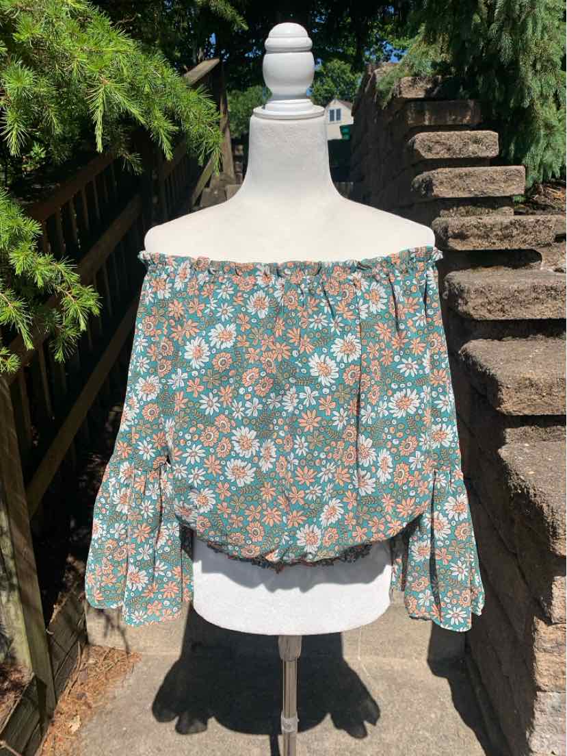 Off-shoulder blouse with long puffed sleeves in green fabric featuring a small pink and white floral print.