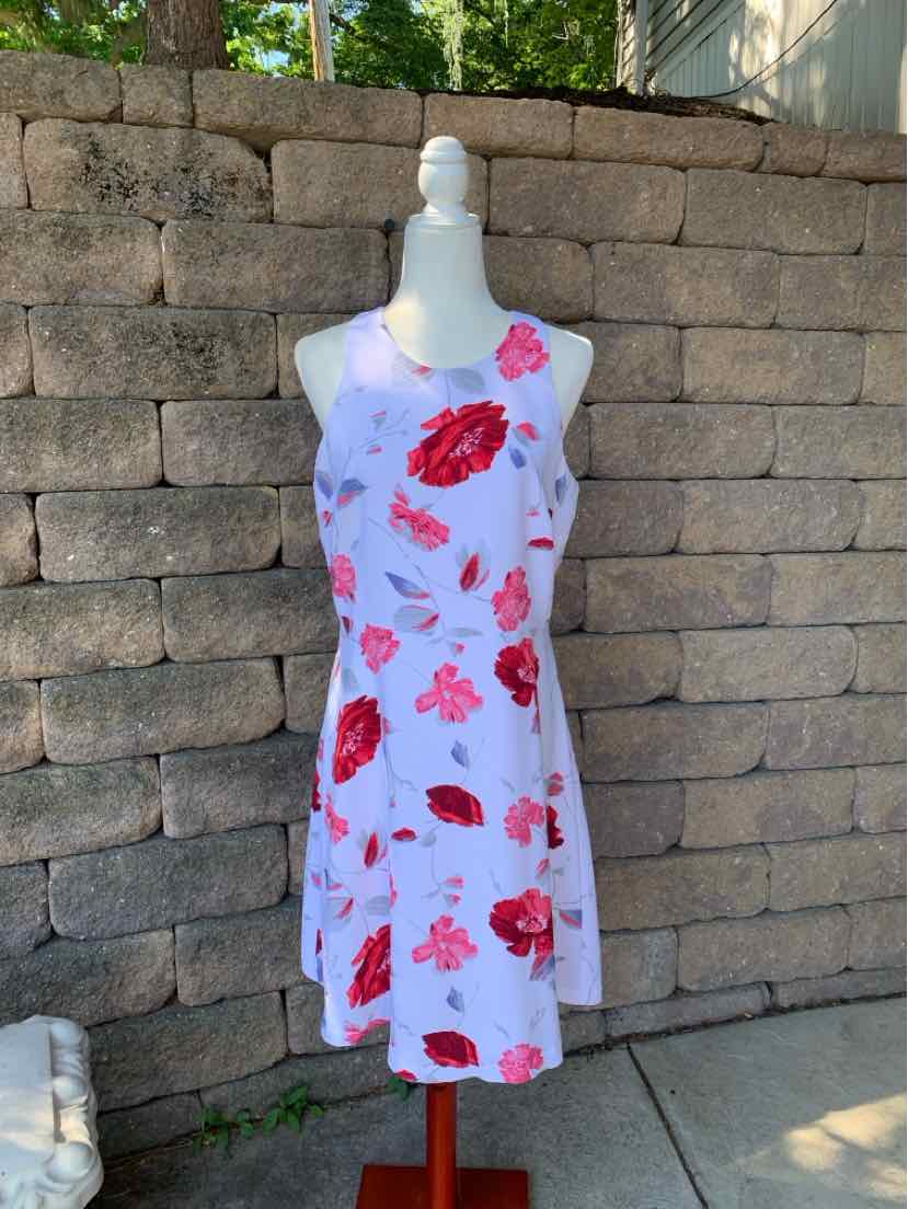 Sleeveless white dress with red and pink floral print, knee-length, fitted waist.
