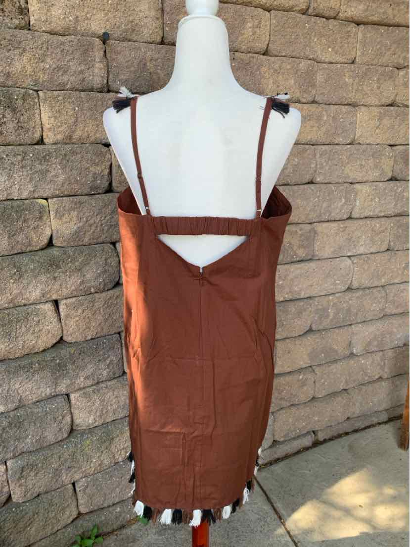 Rust-colored sleeveless dress with adjustable straps and a small back cutout, accented with white and black trim at hem.