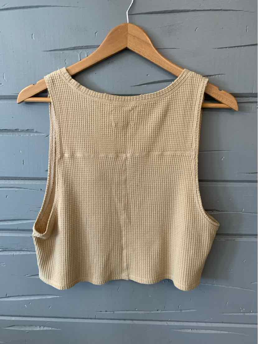 Tan ribbed knit cropped tank top with wide armholes and a scoop neckline on a wooden hanger.