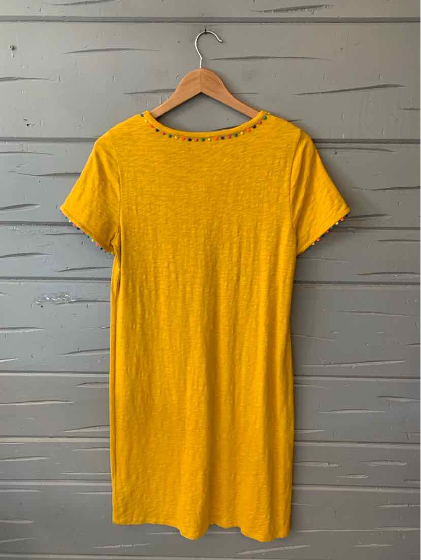 Yellow short-sleeve dress with round neckline on wooden hanger against gray wall.