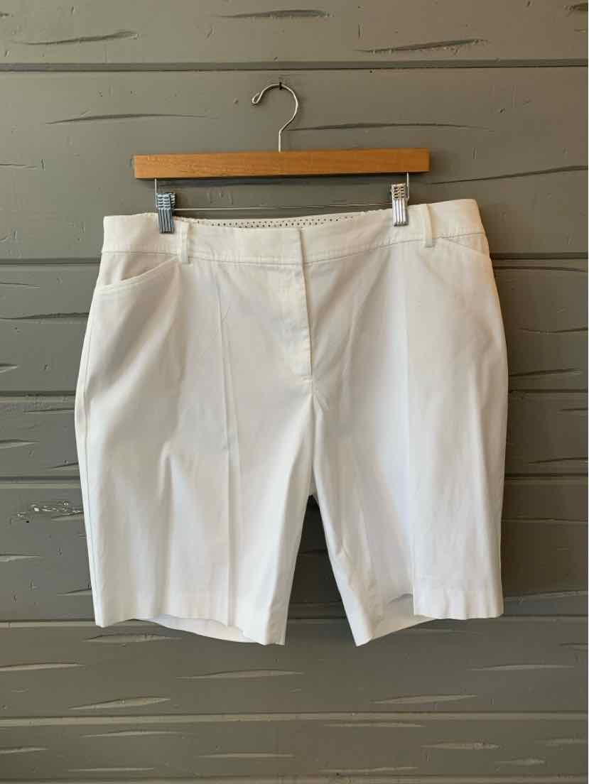 White tailored knee-length shorts with front pleats and side pockets, hanging on wooden hanger.