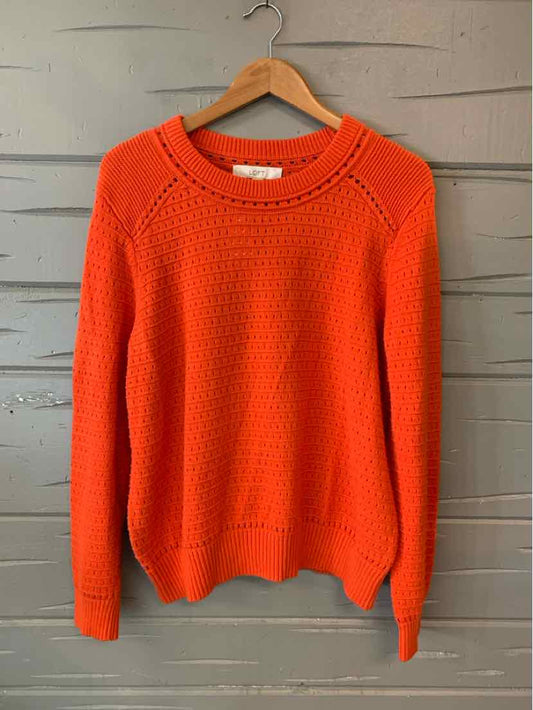 Orange knit crewneck sweater with textured pattern in XL size hanging on wooden hanger.