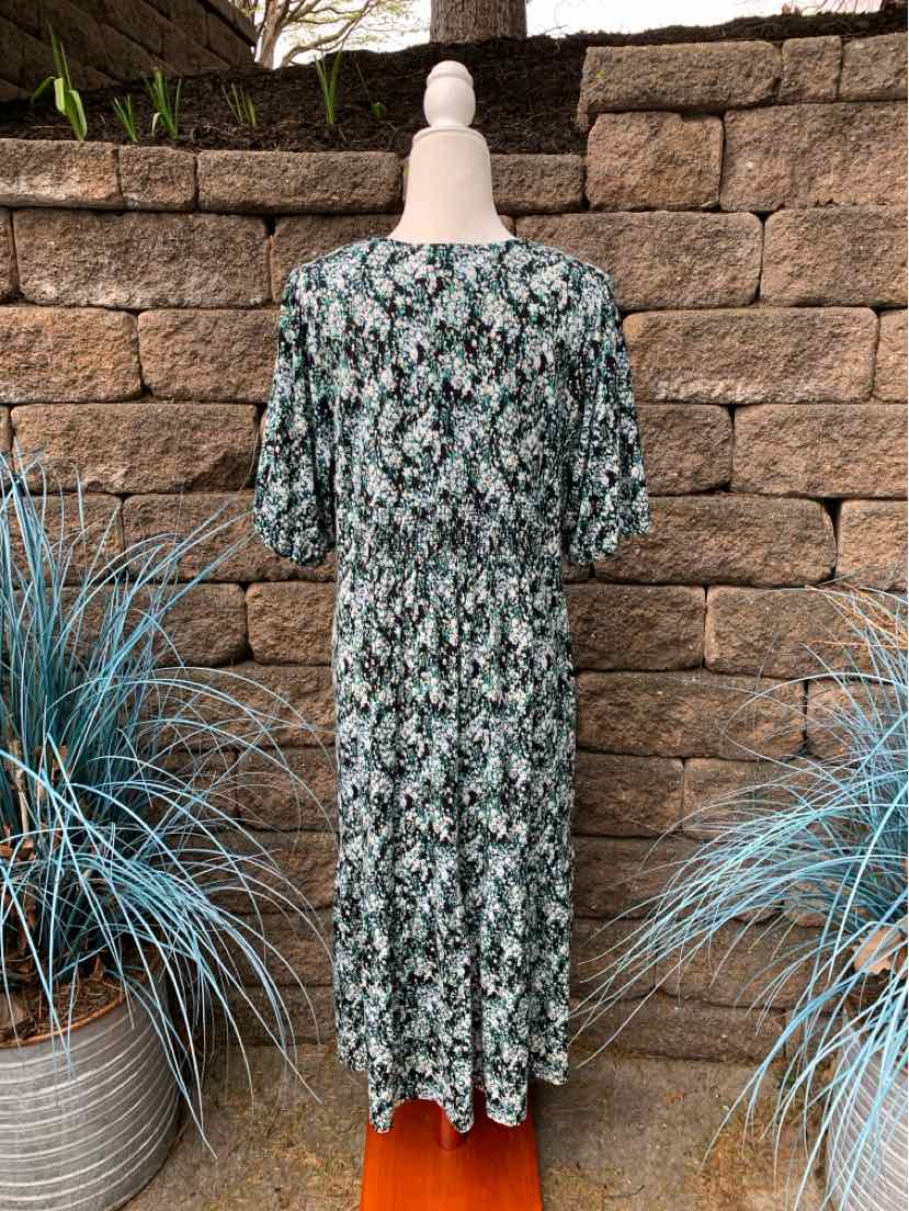 Long floral print dress with short puff sleeves in green and white tones.