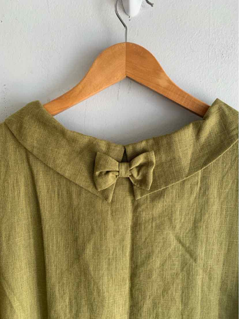 Olive green linen blouse with wide collar and decorative bow at front neckline.
