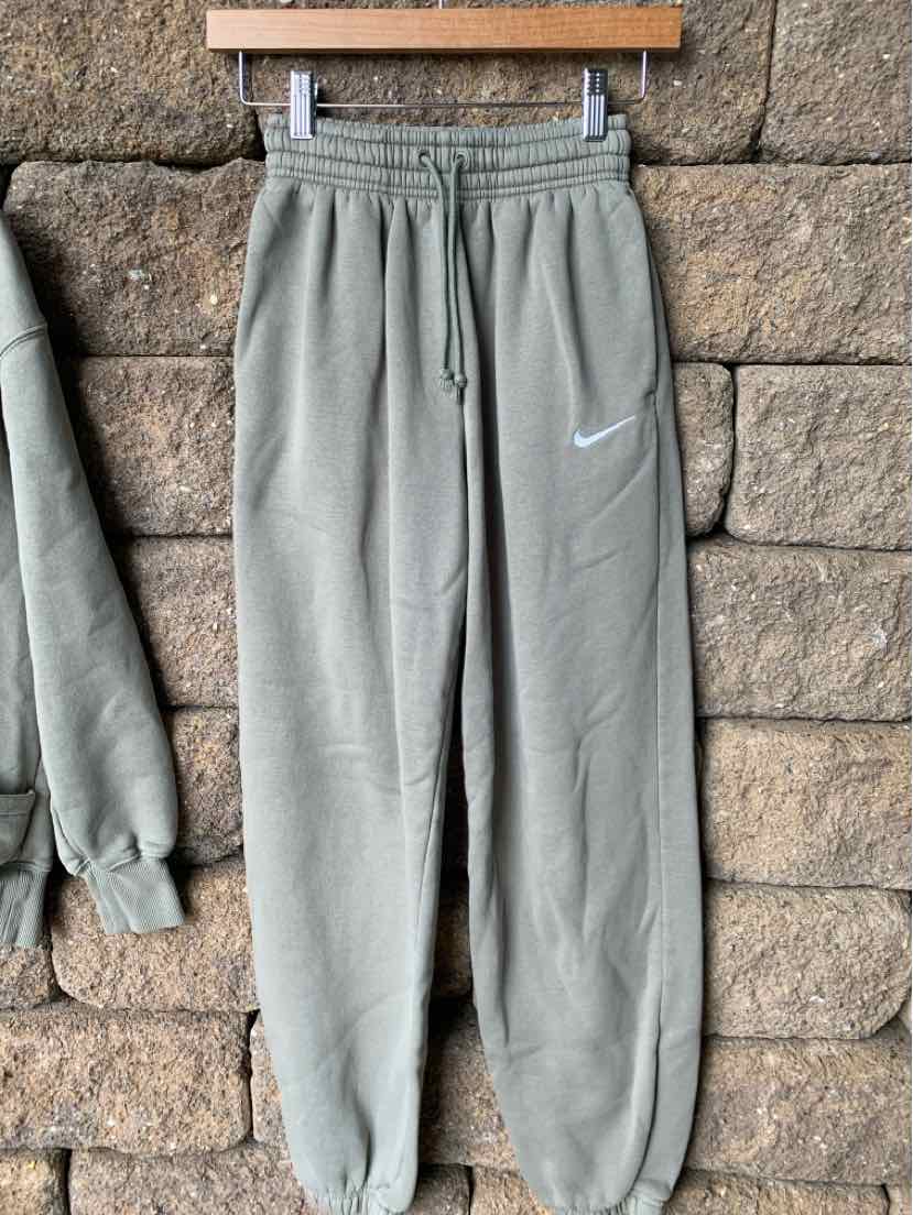 Light gray Nike sweatpants with elastic waistband and cuffs, white swoosh logo on left thigh.