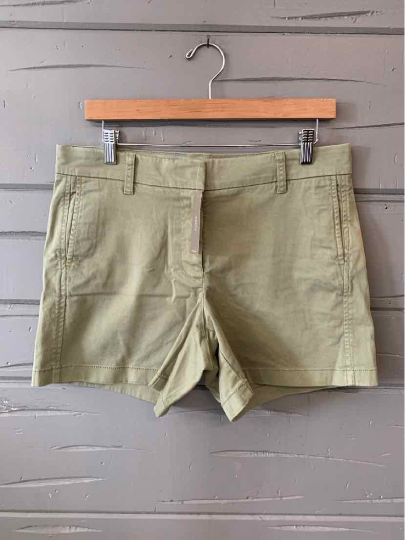 Light olive green cotton shorts with front pockets and zipper closure, size 8.
