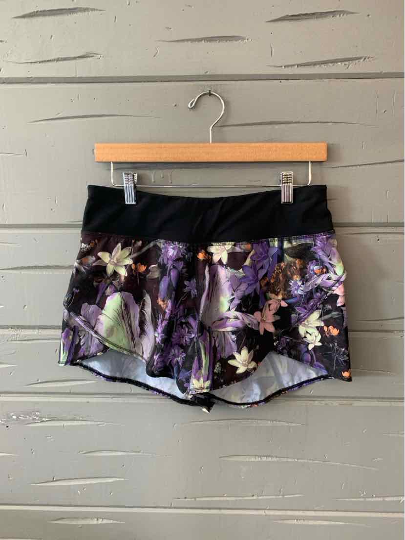 Black waistband floral patterned lavender athletic shorts with a relaxed fit.