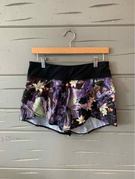 Black waistband floral patterned lavender athletic shorts with a relaxed fit.