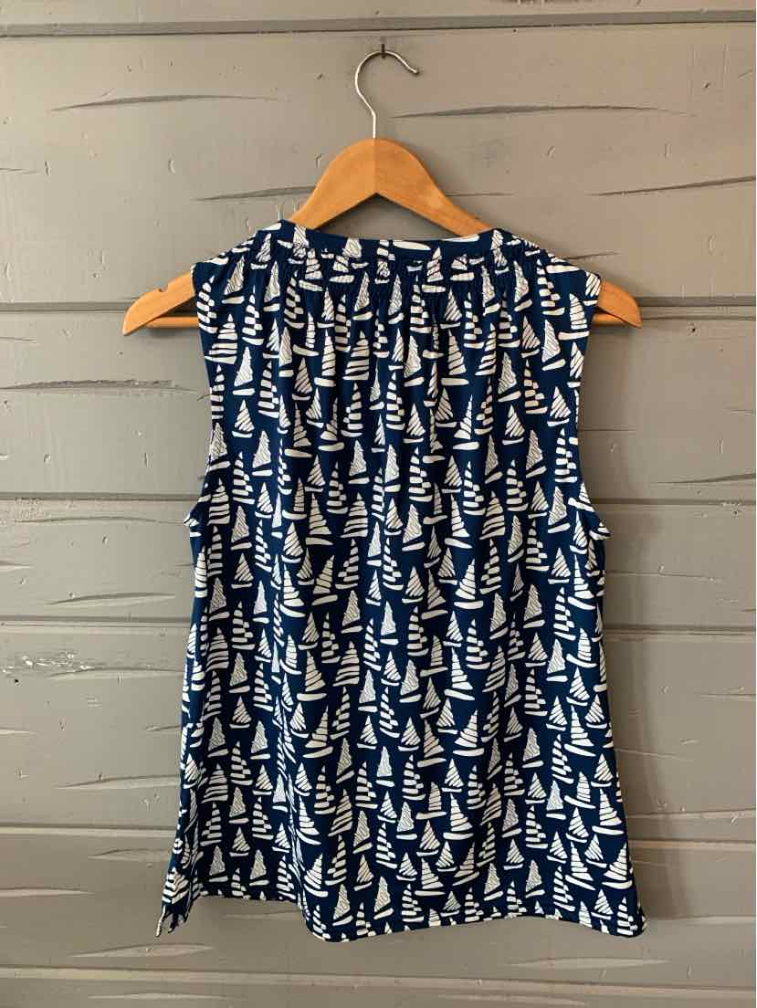 Navy sleeveless dress with white sailboat pattern and round neckline on wooden hanger.