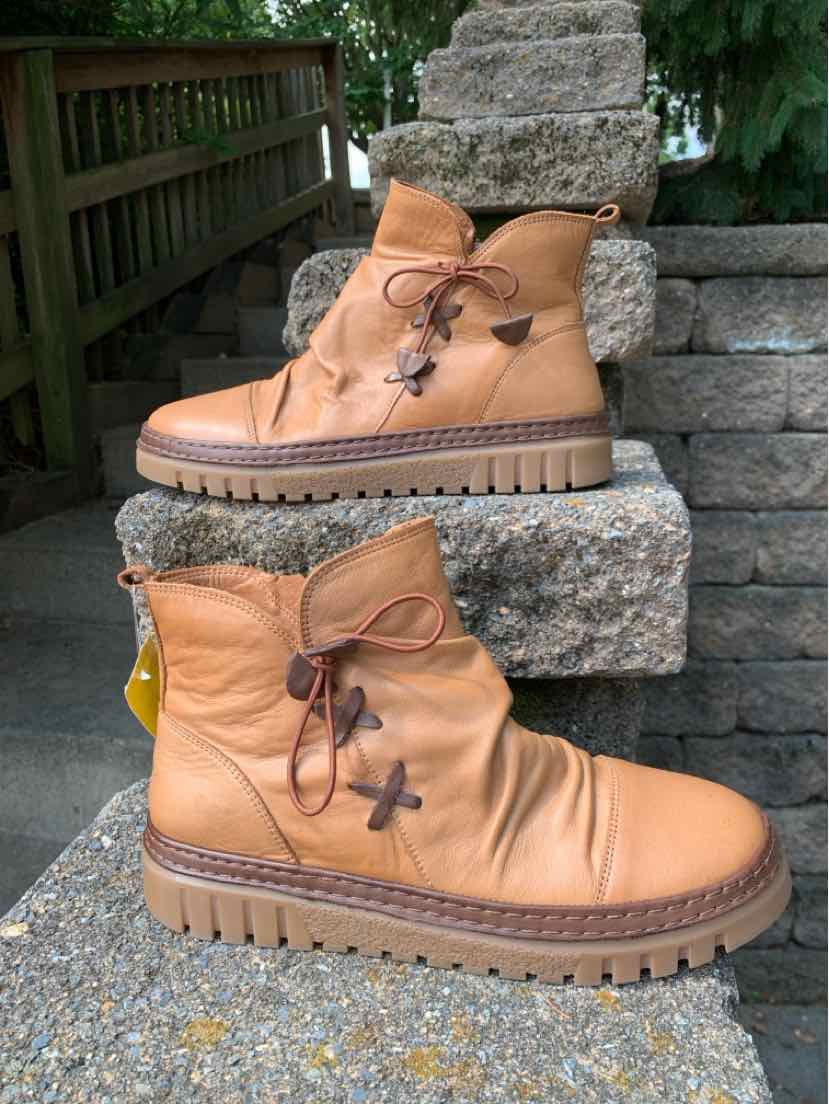Tan leather ankle boots with lace-up front, padded collar, and rugged rubber sole.