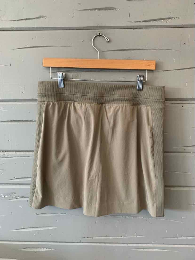 Taupe knee-length skort with elastic waistband and side pockets, made of lightweight fabric.