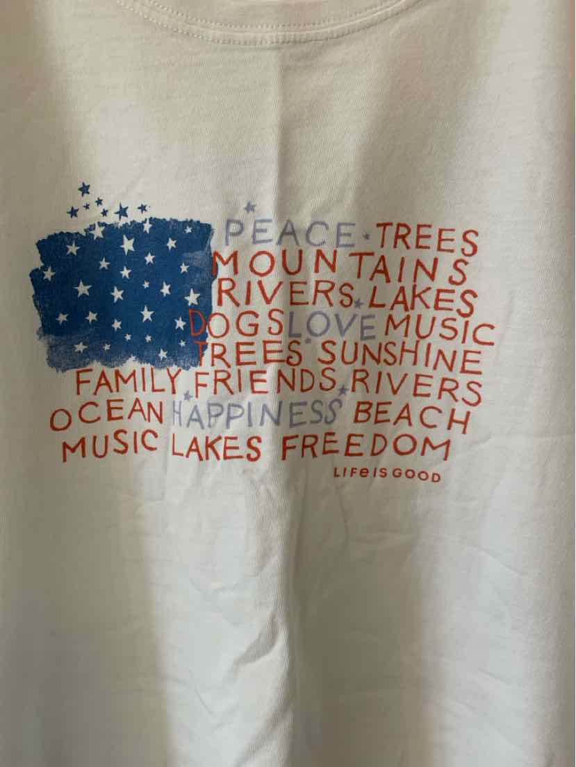White cotton t-shirt with colorful text in red and blue forming a shape of the United States flag and words like peace,.