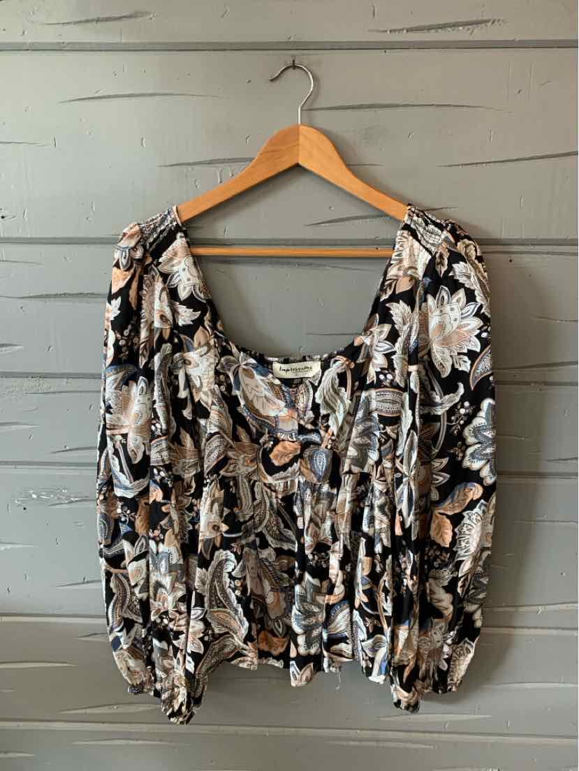 Black long-sleeve blouse with large beige and white floral print, gathered neckline, and elastic cuffs.
