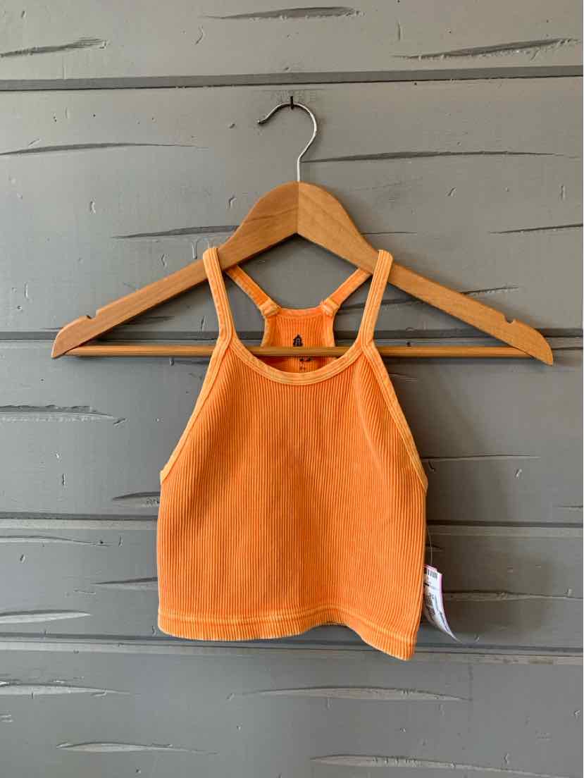 Orange cropped tank top with thin straps and ribbed texture on wooden hanger against gray wall.