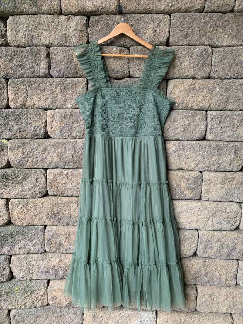Green tiered midi dress with smocked bodice, wide ruffled straps, and mesh hem detail.
