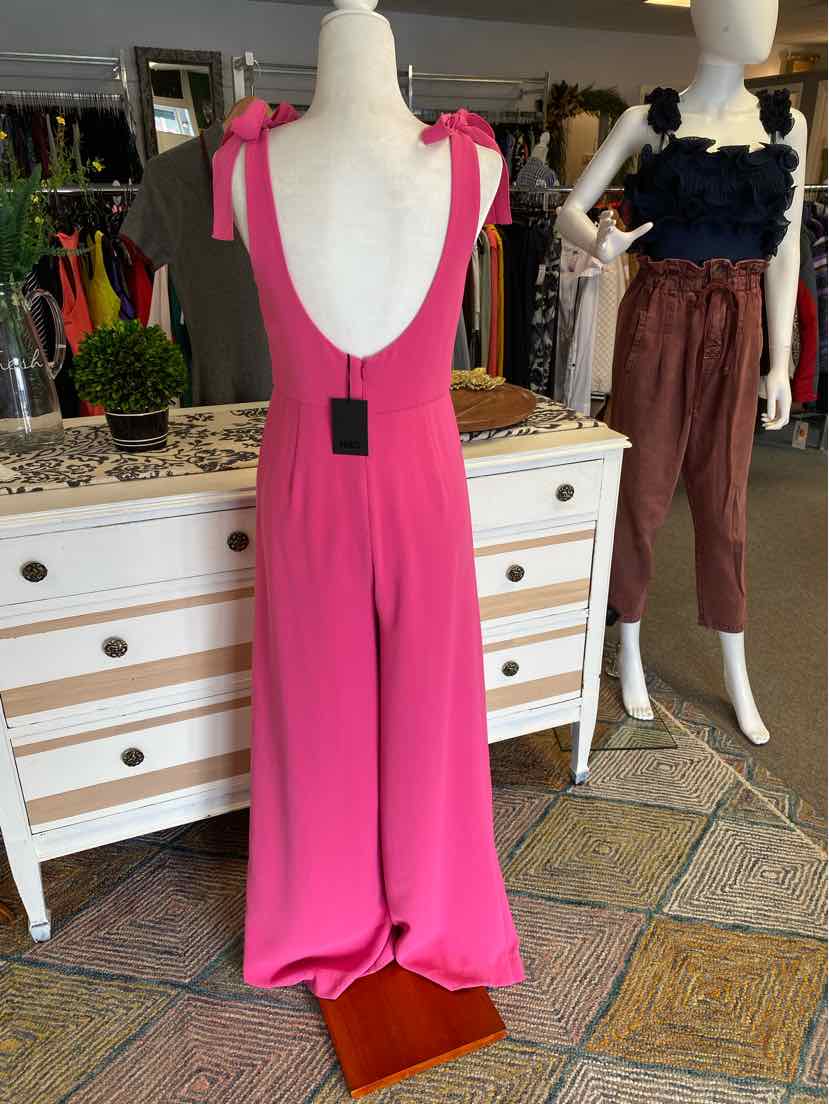 Bright pink sleeveless jumpsuit with deep scoop back and wide-leg pants on mannequin.