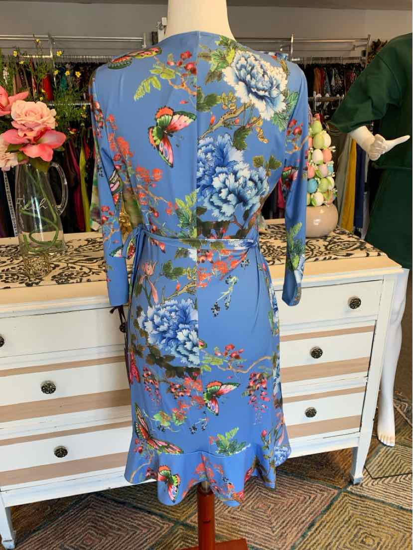 Blue floral short dress with three-quarter sleeves and ruffled hem on mannequin.
