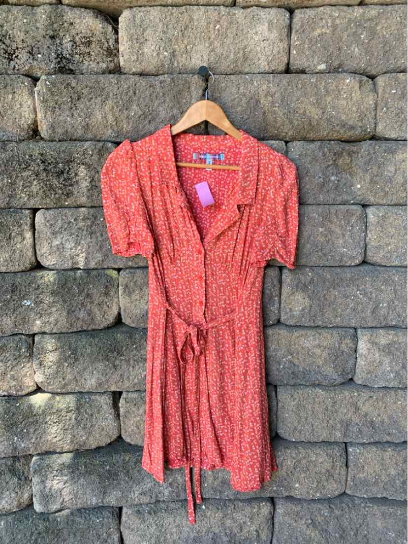 Red floral short-sleeve dress with v-neck, cinched waist tie, and button-down front.